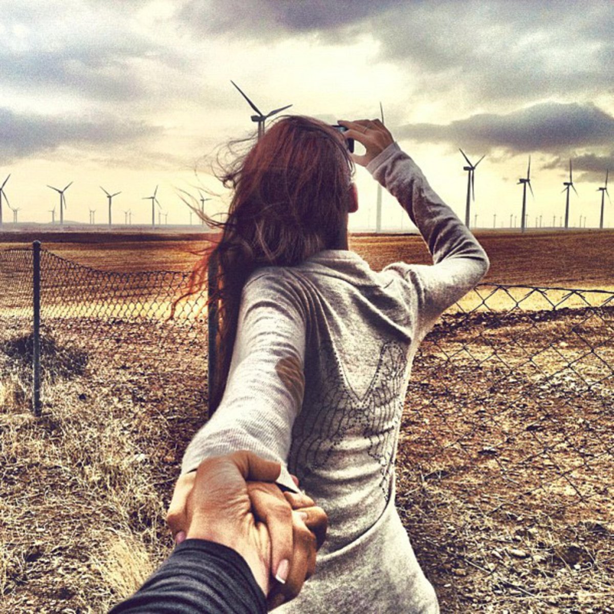 Парень держит девушку за руку