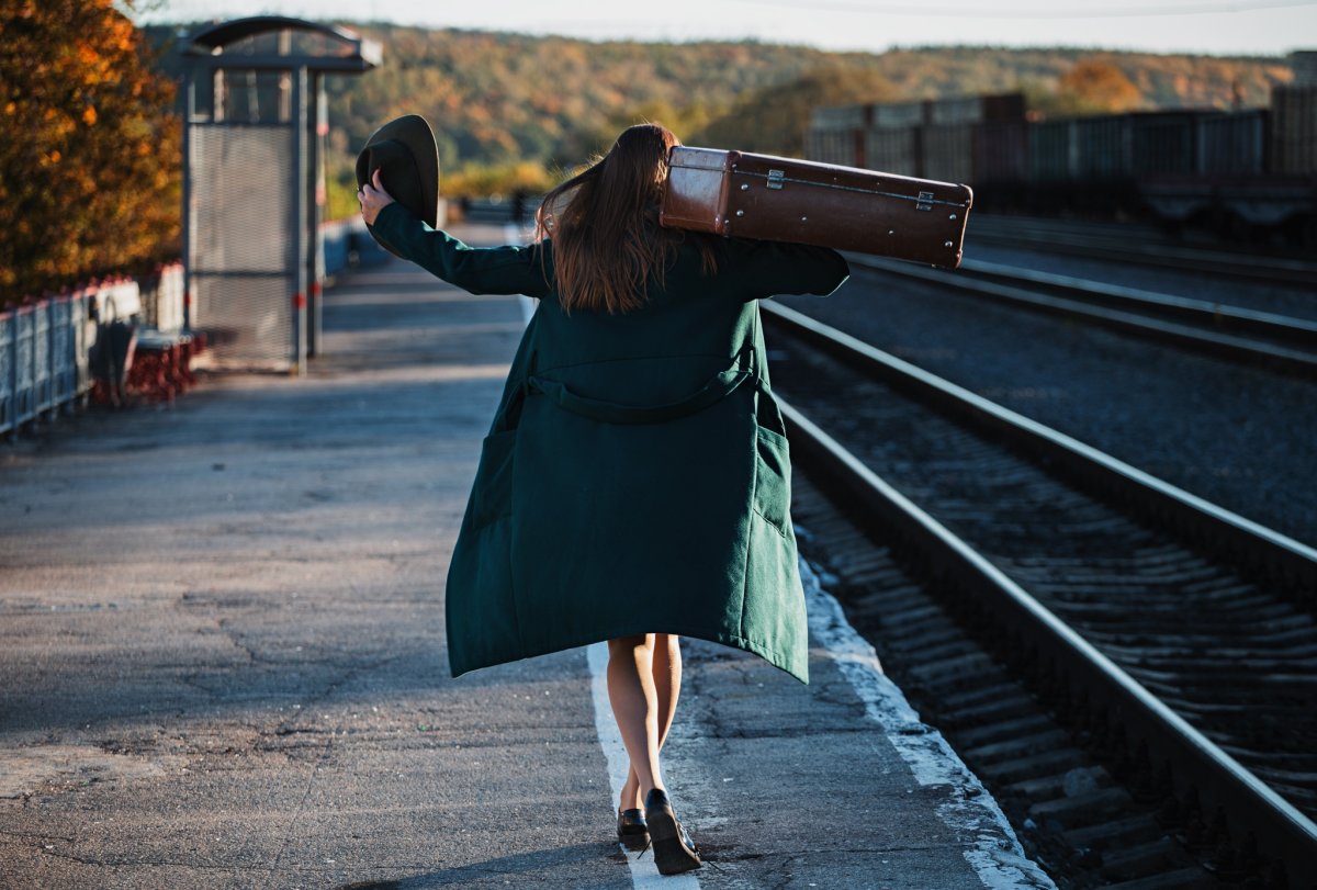 Девушка с чемоданом на дороге
