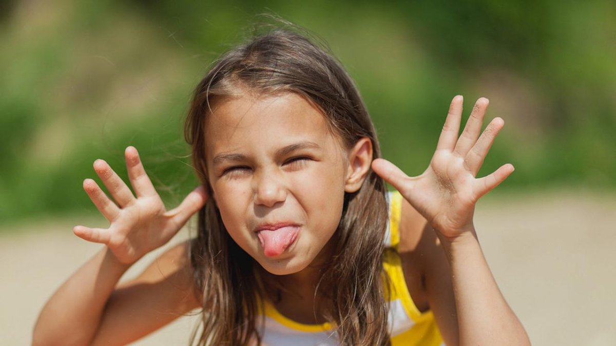 Девочка дразнится и показывает язык