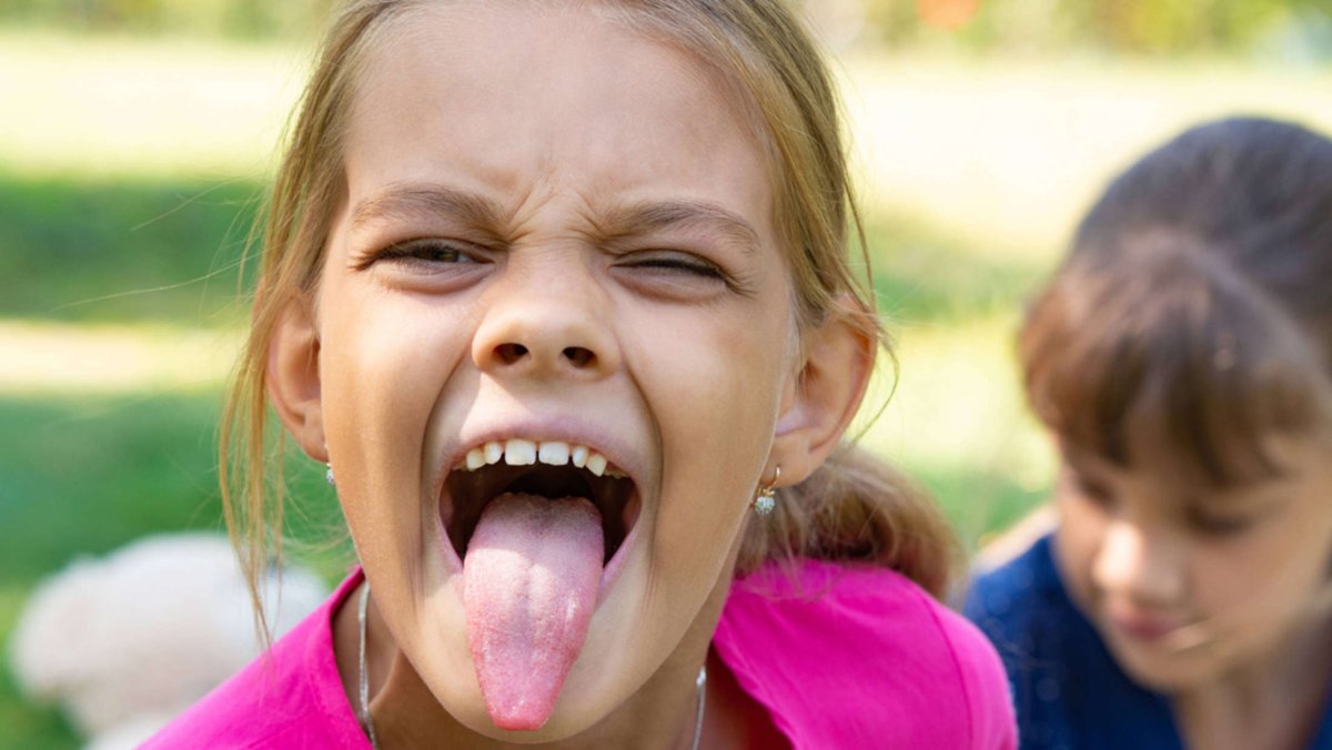 Маленькая девочка с высунутым языком