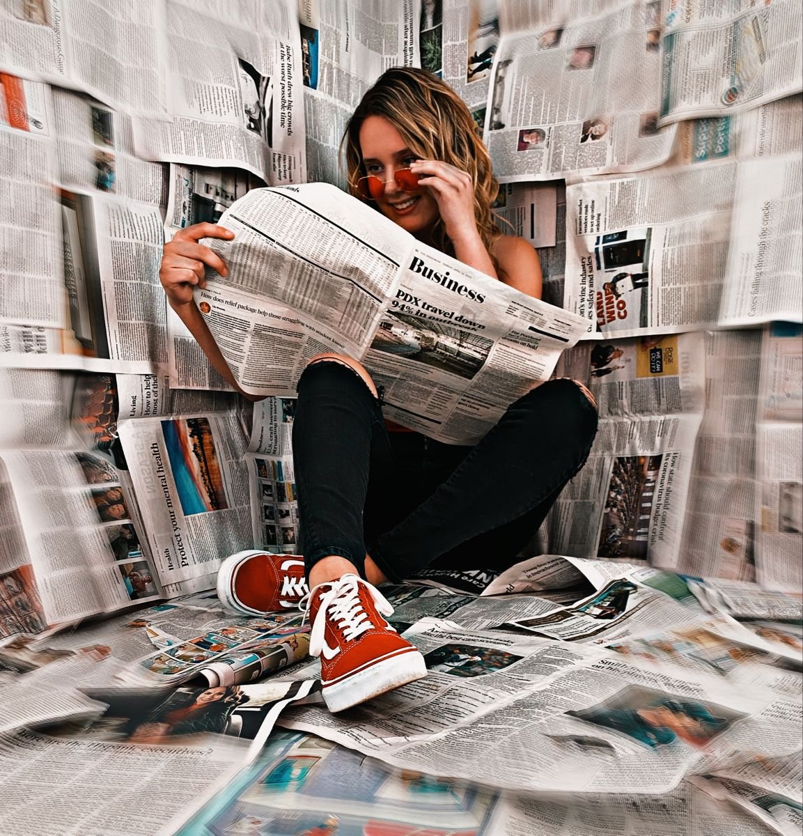 Девушка на фоне газет