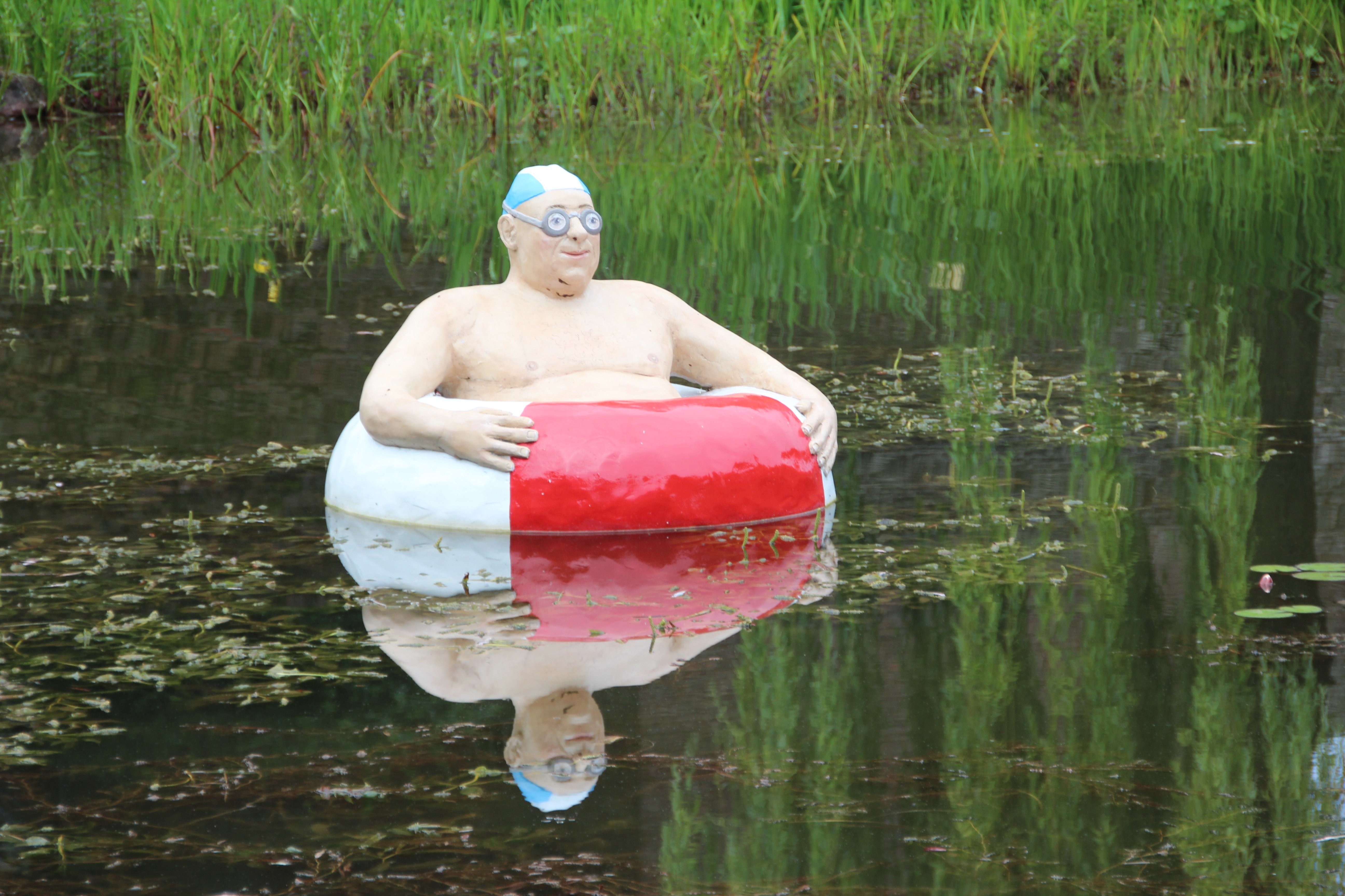Вода на жирной поверхности. Шапочка для плавания смешная. Человек с надувным кругом. Мужчина с надувным кругом.