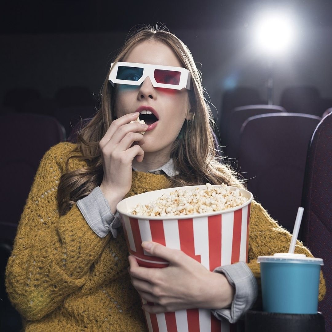 Человек в кинотеатре с попкорном