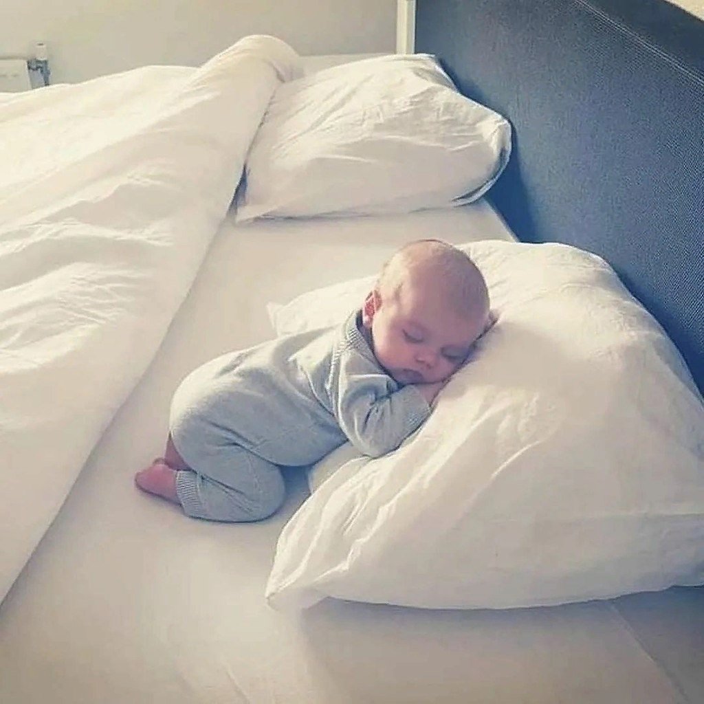 Спящий малыш в круглой кроватке