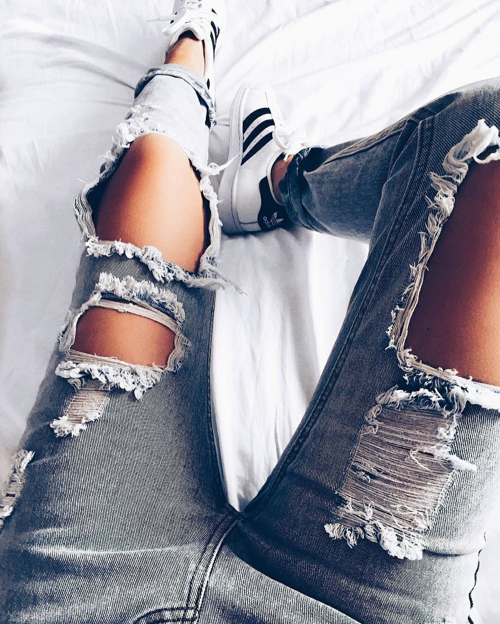 Ноги девушки в рваных джинсах