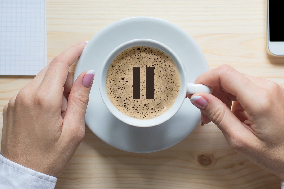 Стаканчик кофе в руке вид сверху