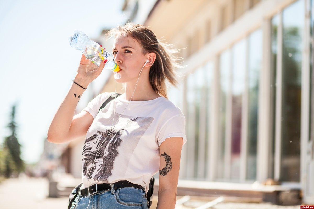 Девушка пьет воду из бутылки