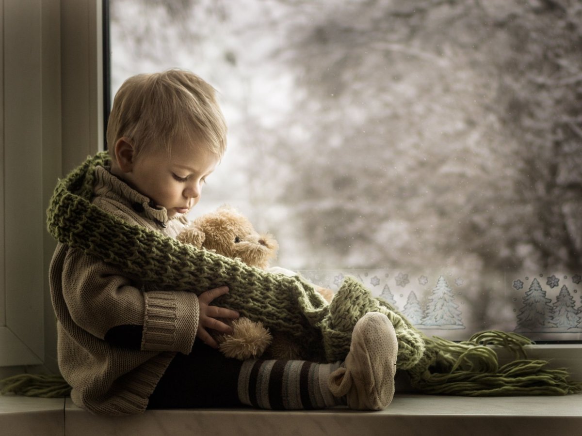 Грустный мальчик у окна