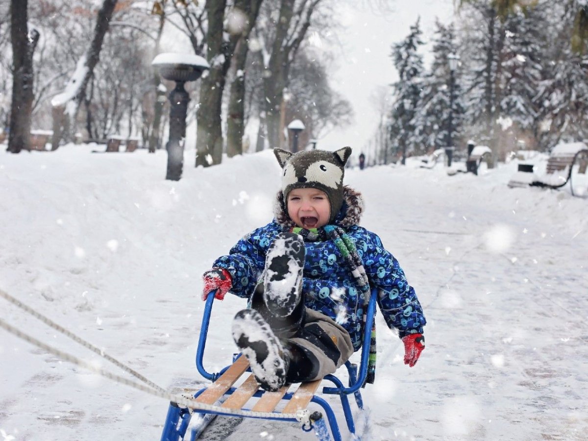 Дети катаются с горки зимой