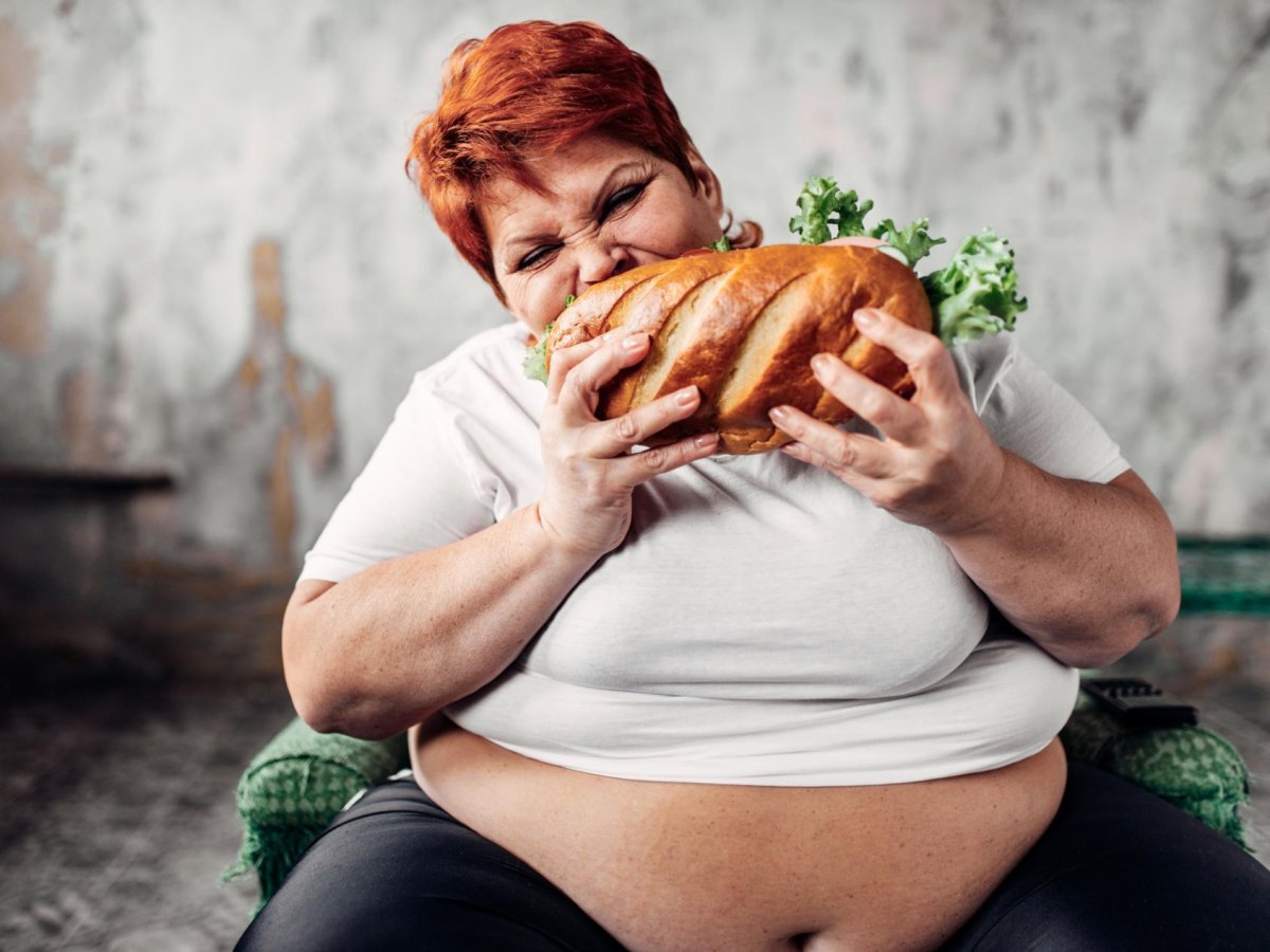 Очень толстая женщина ест
