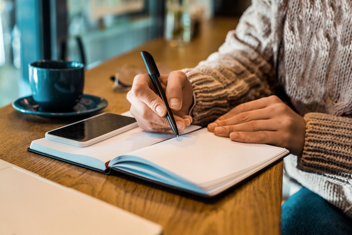 Девушка пишет в блокноте