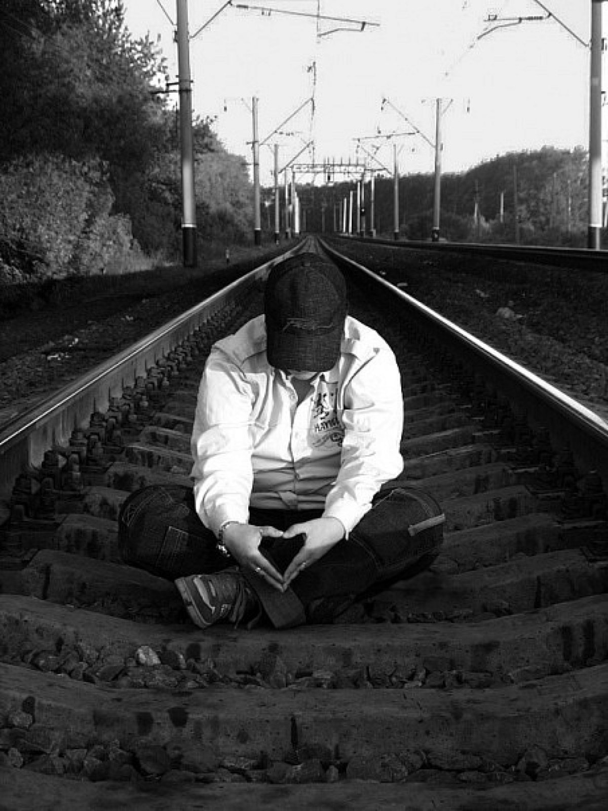 Парень сидит на рельсах